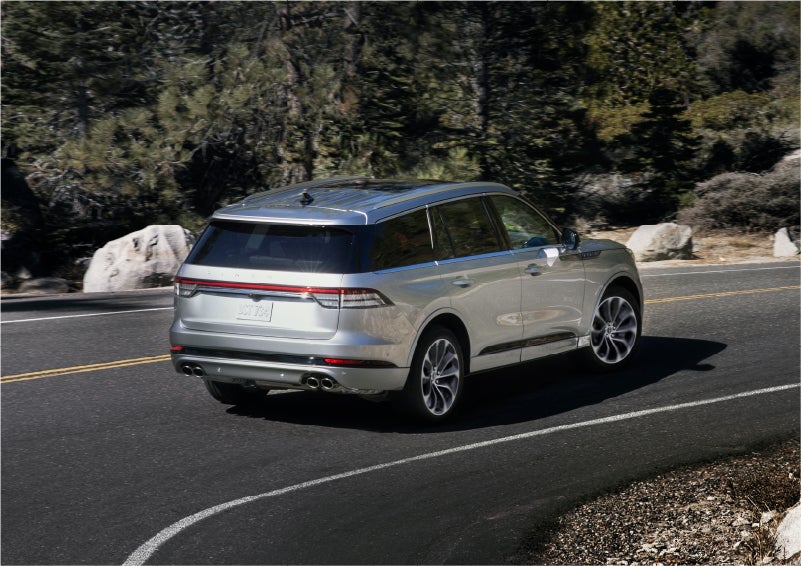A 2023 Lincoln Aviator® Grand Touring model is shown being driven on a tight turn of a mountain road | South Bay Lincoln in Hawthorne CA