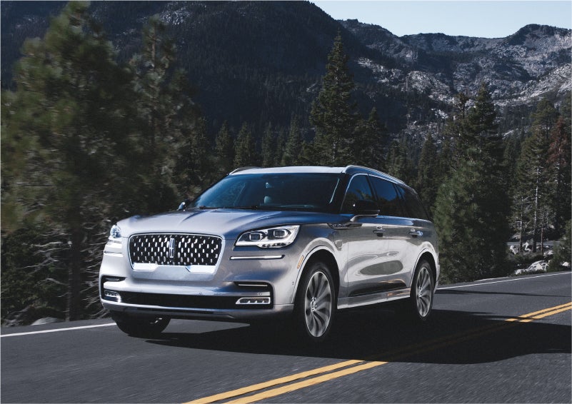 A 2023 Lincoln Aviator® Grand Touring SUV being driven on a winding road to demonstrate the capabilities of all-wheel drive | South Bay Lincoln in Hawthorne CA