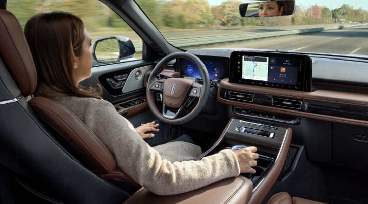 A 2027 Lincoln Aviator® SUV is being driven hands-free on a highway lined with trees. | South Bay Lincoln in Hawthorne CA