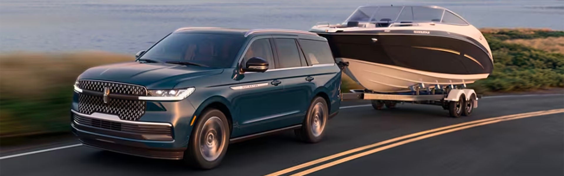 A 2025 Lincoln Navigator pulling a boat trailer cruises down the highway.