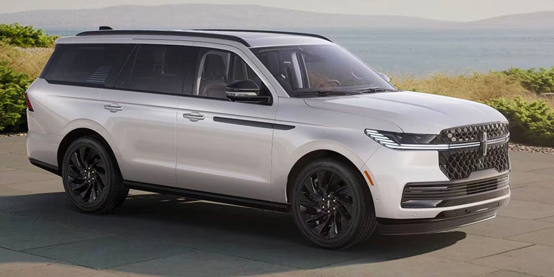 A 2025?Lincoln?Navigator parked beside a scenic road, surrounded by beautiful nature.