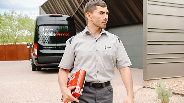 A person holds a smartphone with the Lincoln Way™ App displayed on it.