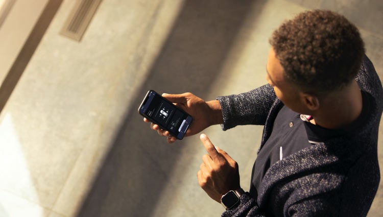 A person holds a smartphone with the Lincoln Way™ App displayed on it.